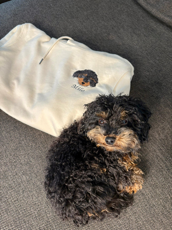 Milo naast de hoodie met zijn geborduurde portret